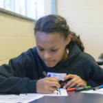 At a Penn College Career Day, a middle-schooler learns the color-coded programming language that will make an Ozobot dance. (Photo by Tia G. La, student photographer)