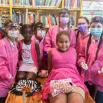 Pretty in pink: Instructor Rhonda J. Seebold snapped a photo of students with children whose outfits just happened to be a perfect match to the students’ bright lab jackets. The students were providing sealants.