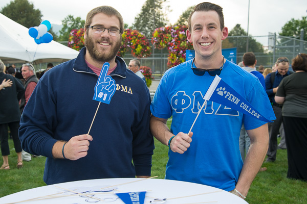 Jordan D. Suter (left) and Paul M. Lasell are Penn College Proud, sporting appropriate accessories from a photo-ready prop table.