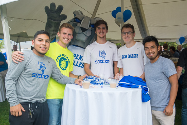 The college mascot enjoys refreshments with members of the men's soccer team.