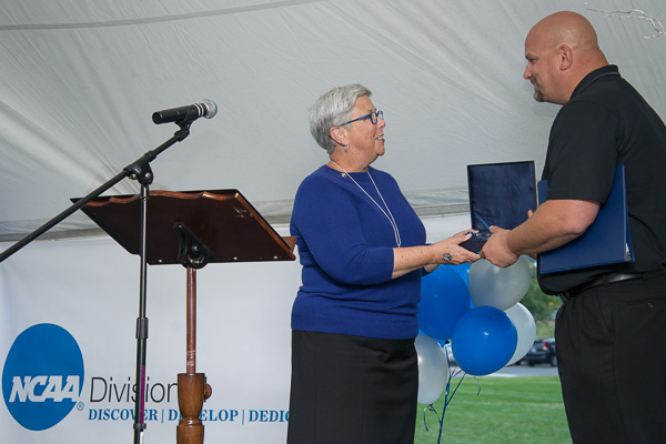 Penn College President Davie Jane Gilmour presents the official commemoration of the college's NCAA membership to John D. Vandevere, director of athletics ...