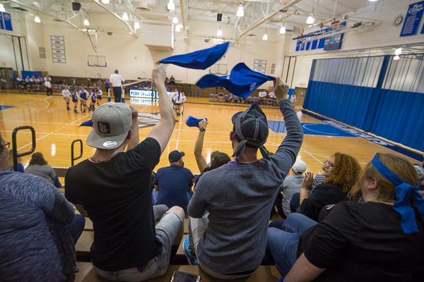 Wildcat fans celebrate a volleyball point by waving blue towels, among the celebratory night's giveaways.