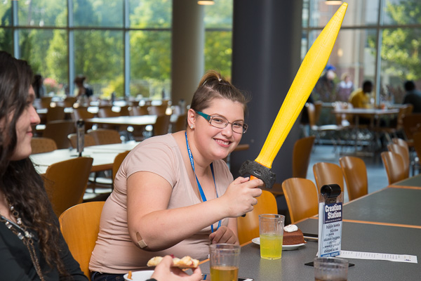Fun while feasting! Diner Emma M. Mikulecky, a baking and pastry arts student from Williamsburg, brandishes a toy sword.