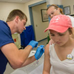 Under the watch of Barbie D. Harbaugh, instructor of nursing, Bryce J. Merrill administers a flu shot to Kaitlyn E. Miller, a student in applied health studies, radiography concentration.
