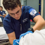 Nursing student Michael G. Covone, like his classmates, uses both technical and communication skills while providing a flu vaccine to graphic design student Alexandria C. Wood.