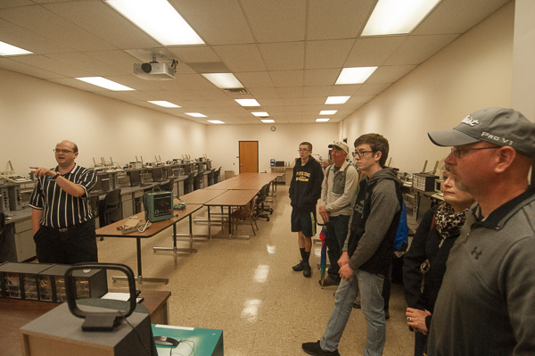 Electrical instructor Scott A. Seroskie (left), a 2006 graduate in electromechanical maintenance technology, welcomes families to the industrial electronics lab in the School of Industrial, Computing & Engineering Technologies.
