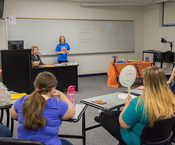 Michaeleen G. McNamara, assistant professor of human services/social services-psychology, and applied human services student Hannah M. Strosser, of Williamsport, lead visitors in a competition-style learning experience.