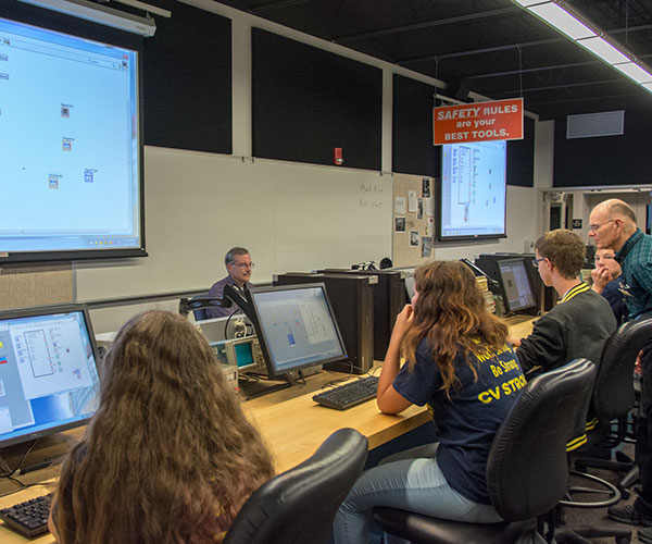Mark A. Rice, instructor of electronics (at desk), leads high-schoolers in a session titled “Virtual Instruments and Graphical Programming,” while Bill C. West (far right), assistant professor of electronics, circulates to help keep participants on track.
