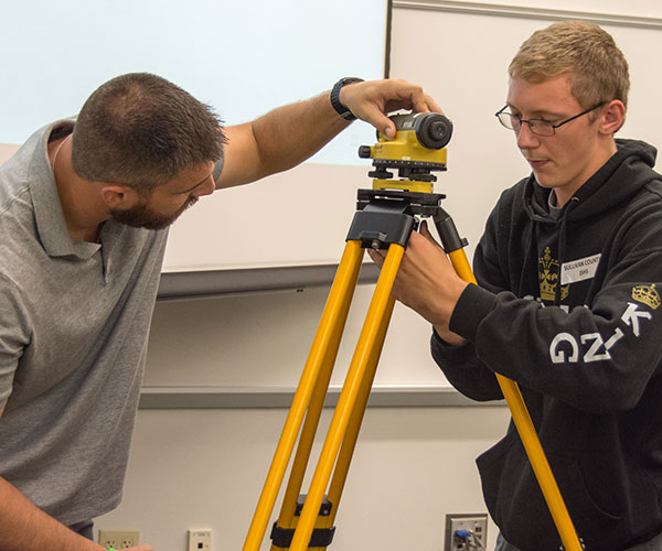 Civil engineering technology student Matthew R. Buck (left), of Danville, leads students from Sullivan County High School in setting up a level during a session on surveying and civil engineering.