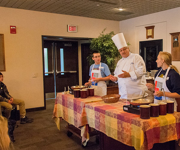 In Le Jeune Chef Restaurant, one of the learning labs for students in Penn College’s hospitality majors, Chef Paul E. Mach, assistant professor of hospitality management/culinary arts, guides students in a hands-on demonstration for their classmates.