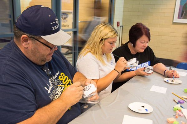 Kassidy A. Svenson, of Auburn, an applied human services major, joins her parents in hand-painting a keepsake.