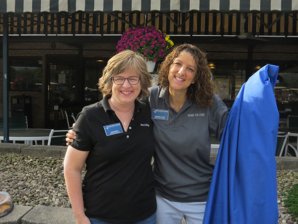 Angie E. Myers (left) director of annual giving, and Kimberly R. Cassel, director of alumni relations, greet golfers at White Deer.