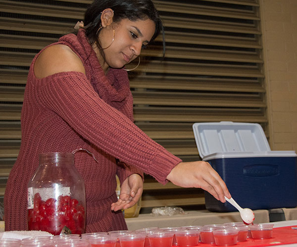 Hospitality management student Noeiris Pliego spoons maraschino cherries into her “Crand-Dandy Cooler,” featuring cranberry, pineapple, orange and lemon juices and club soda.