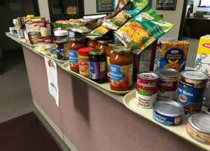 Cafeteria trays are piled with donated non-perishables in a Penn College office, an effort duplicated across campus in support of The Cupboard.