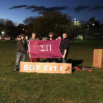 Sigma Pi brothers hoist their fraternity's flag while raising visibility of the homeless.