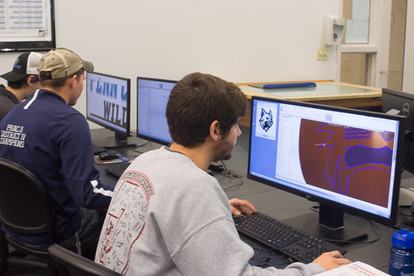 Students, including Jason P. Hill (foreground), of Allenwood, try their practiced hand at replicating the Wildcat logo.