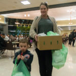 Laura M. Machak, college transitions specialist, brings along some young muscle to cart the carryout.