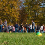 Competitors gather in a large field in preparation for the next event.