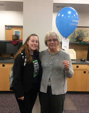 Student development assistant Kacey J. Shatzer (left) hand-delivers birthday wishes to donor Linda M. McFadden, assistant bursar.