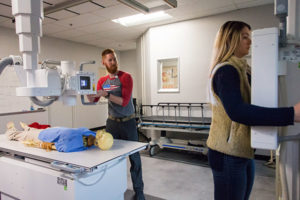 Penn College radiography student James P. Lougee, of Watsontown, simulates positioning the lab’s digital radiology equipment to take a chest X-ray of fellow student Kayla E. Rosbach, of Forksville, in the renovated radiography lab.