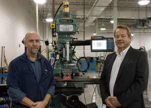 Rudy Gebhard (right), senior sales representative for Southwestern Industries Inc., and Richard K. Hendricks Jr., instructor and department head of automated manufacturing and machining at Penn College, with a TRAK KMX milling machine donated by Southwestern Industries