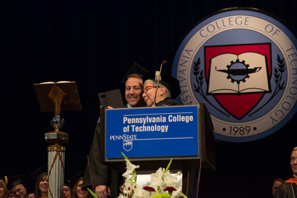 After turning his tassel, the college president takes a selfie with the student speaker.