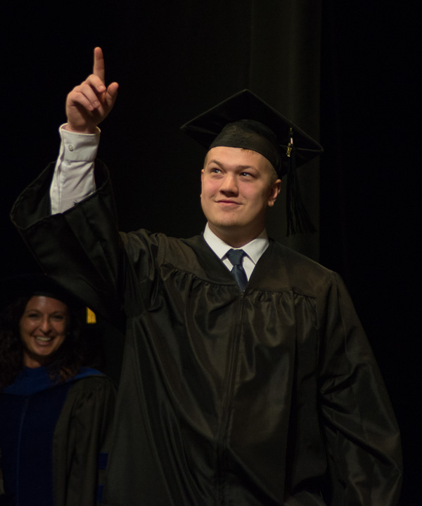 Pointing to fans in the loge is Cody A. Hill, of Bellefonte, graduating in business administration: marketing concentration.