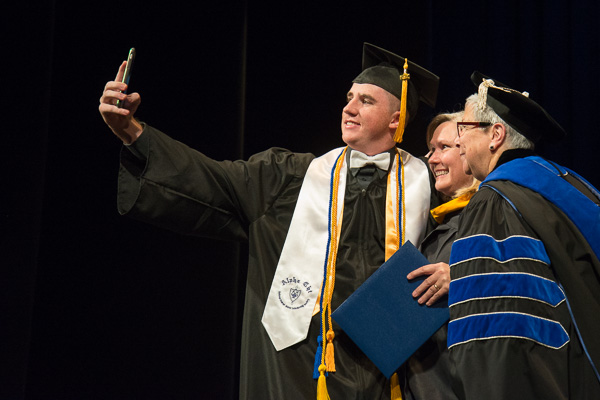 Engineering design technology graduate Richard M. Wood with his mother, Anita R., associate professor of computer information technology, and the college president. 