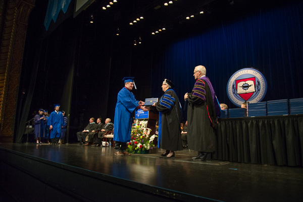 The stage is bathed in a Wildcat-blue glow.