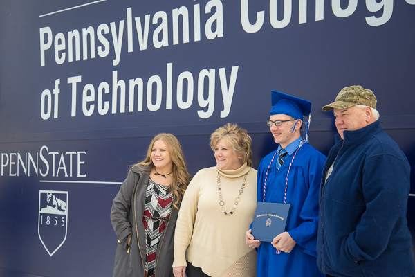 Samuel H. Bressler, a welding technology grad  from Curwensville, poses with family at the campus entrance.
