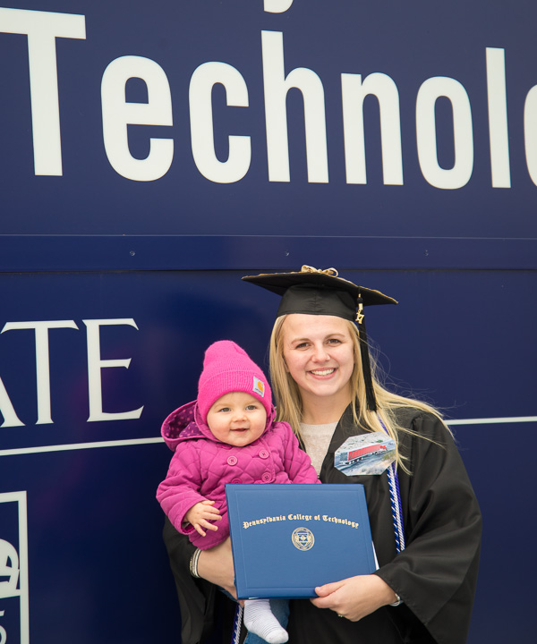 Alayna R. Bertothy, of Philipsburg, a nursing grad, makes a memory with her niece.  (She is wearing a photograph of her parents' truck; they were traveling for work and could not attend.)