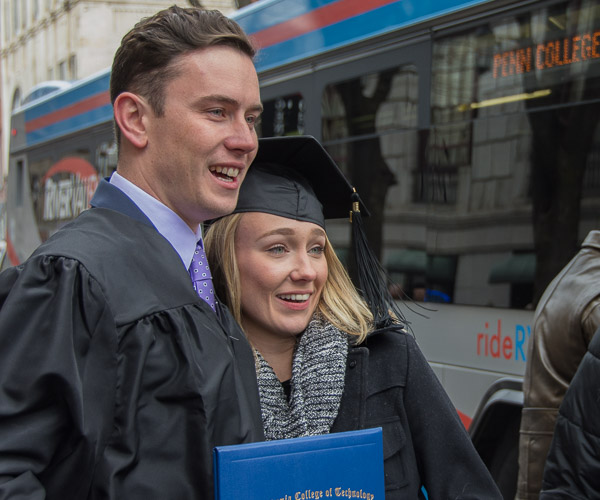 A grad shares his accessories with a loved one.