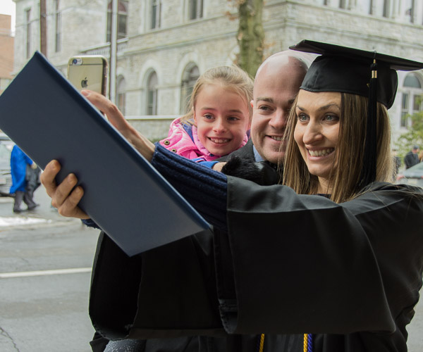 Nursing graduate Elena I. Kranz, of Williamsport, takes a selfie with her boyfriend and daughter.