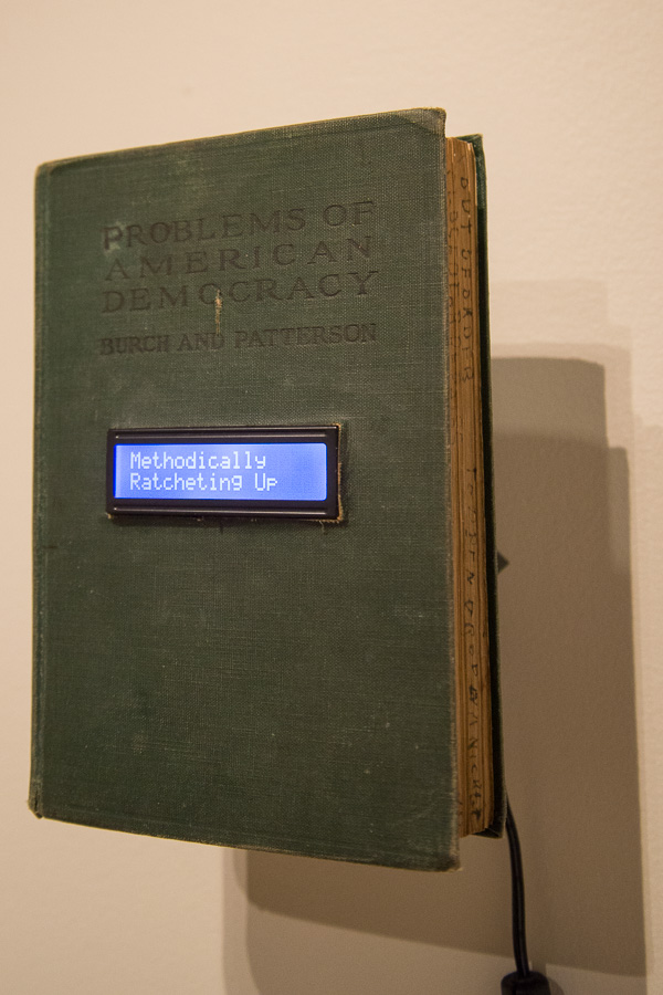 Presenting an LCD display flipping through random news quotes broadcast during the spring of 2017, this work by Kevin H. Jones offers an old-meets-modern take on “Problems of American Democracy.”