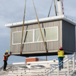 The made-in-the-USA unit is lowered onto the bleachers.