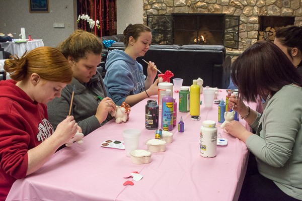 With a cozy fire glowing in the near distance, students enjoy a craft project with their