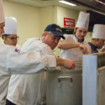 Chef Frank M. Suchwala (in blue cap) stirs a pot of mushroom bisque as student Nolan S. Lester (left) adds stock. Others involved include (from left) Amaris T. Smith, Dylan H. Therrien, William D. Benedetto and Austin B. Ovens.