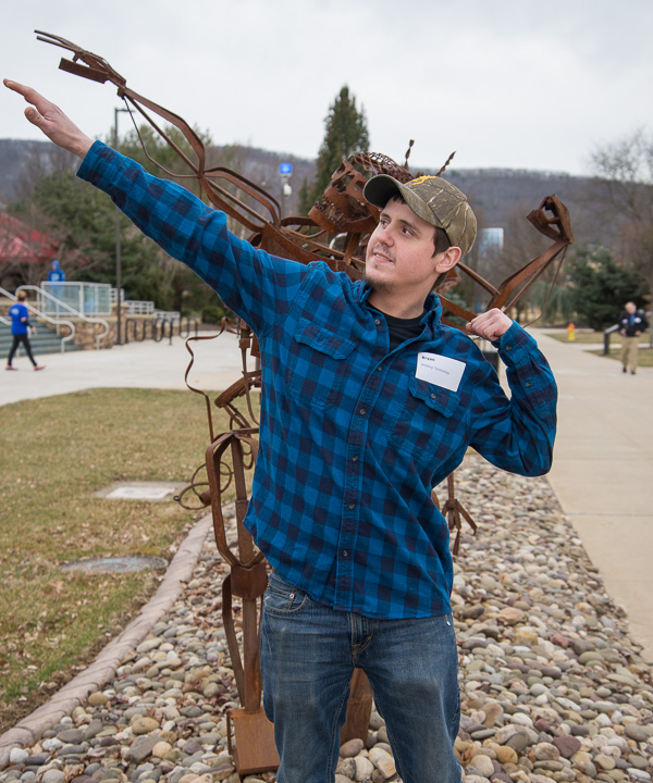 On his way back from Career Fair, Bryan M. Wagner honors a photographer's request that he replicate the forward-looking stance of one of the “Student Bodies” welding sculptures along the campus mall. Wagner, of McAdoo, is in welding technology. 