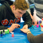 Phi Mu Delta's Raymond L. Long, a building automation technology student from Forest City, takes hands-on education in a fundraising direction.