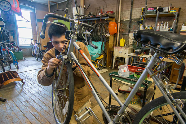 Not unlike the Wright Brothers, whose airborne adventures took off from a bicycle repair shop, aviation maintenance technology student Samuel J. Pham fixes bikes during a service assignment. Pham, of Camp Hill, was among students helping the American Rescue Workers.
