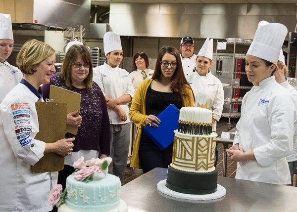 Chefs Susan Notter, left, Sue Mayer, in purple, and Kelsey (Park) Miller, with blue clipboard, provide praise and advice to Breski.