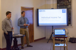 Penn College accounting faculty members Michael D. Shipman (left) and Bob Nolan offer guidance on income tax return preparation at a Thrive International Programs event, held at City Alliance Church in Williamsport.