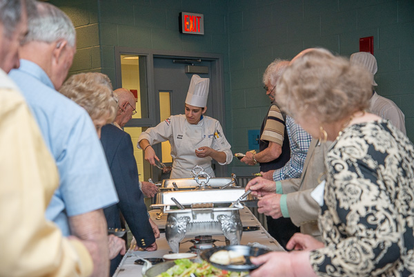 Culinary arts technology student Janelle R. Becker, of Fort Loudon, skillfully serves the special guests. 