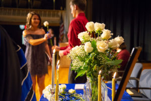 ... and presents each of the attending inductees with a floral welcome to PTK.