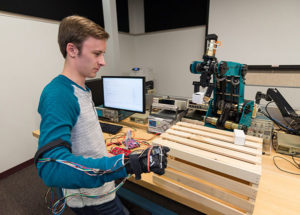 A "wired glove” created by Penn College student David M. Slotnicki, of Oil City, allows him to manipulate the arm of a robot.