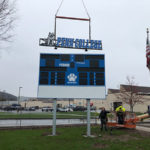 Doing the heavy lifting, a crane helps adorn the Athletic Field scoreboard.
