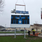 Doing the heavy lifting, a crane helps adorn the Athletic Field scoreboard.