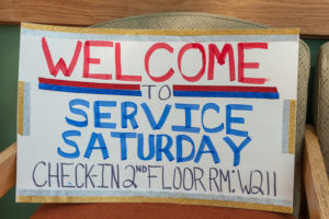 A sign in the ATHS atrium points the way to Service Saturday.