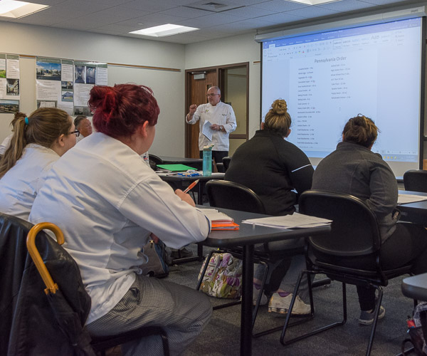 Scourlas reviews production plans for the event’s breads and desserts.