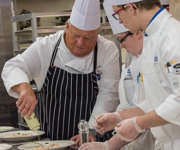 Rosenberg demonstrates the final step in plating the first course – adding a champagne dressing.